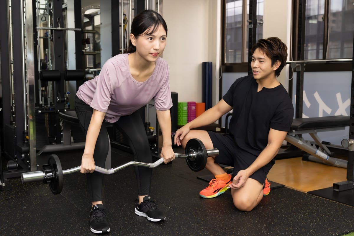 トレーナーから個別指導を受ける女性