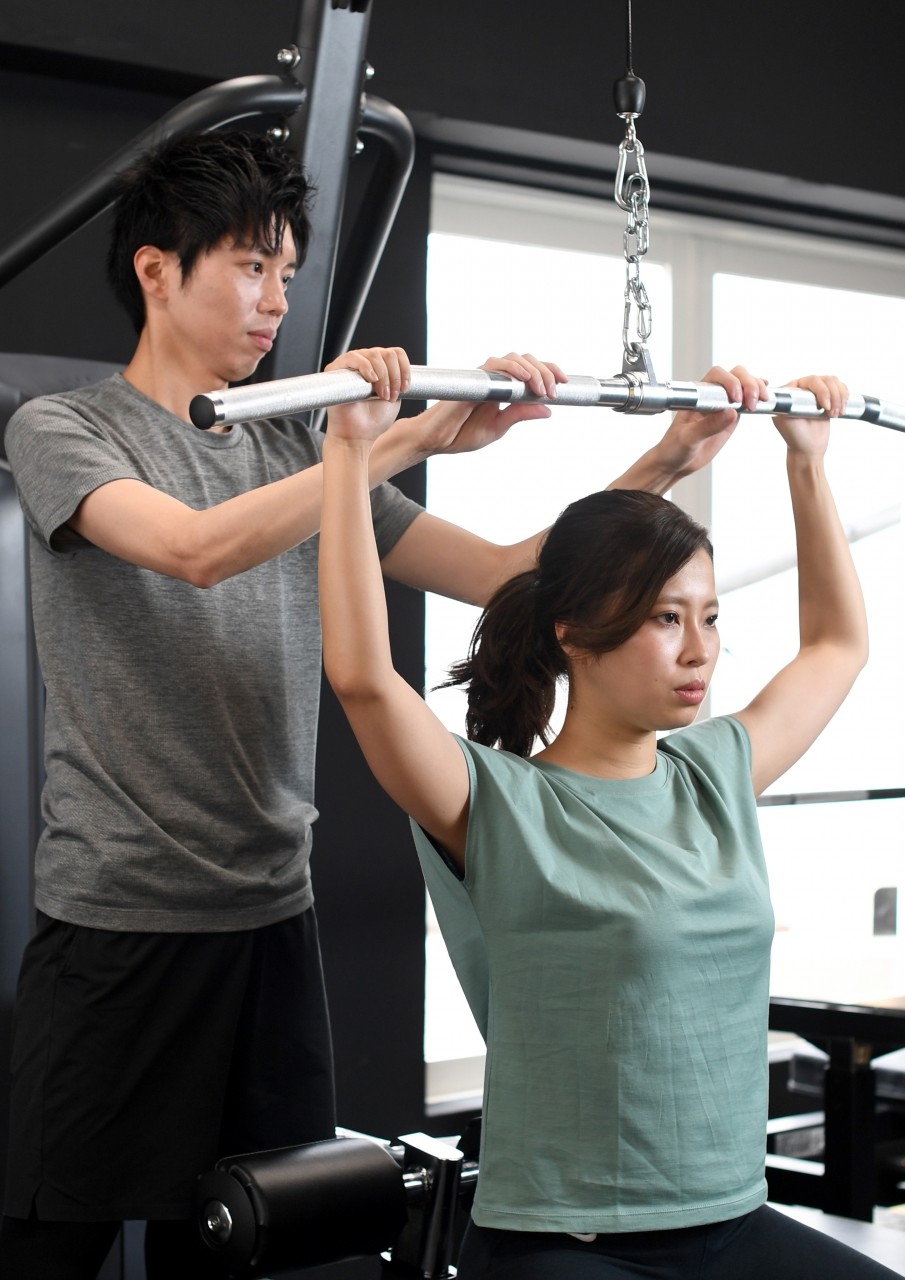 トレーナーからマンツーマン指導を受ける女性